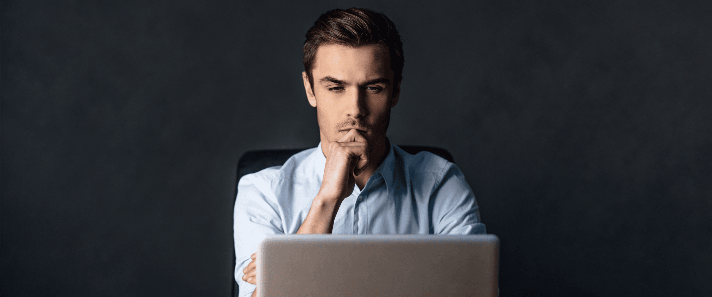Man sitting at a computer in deep thought.